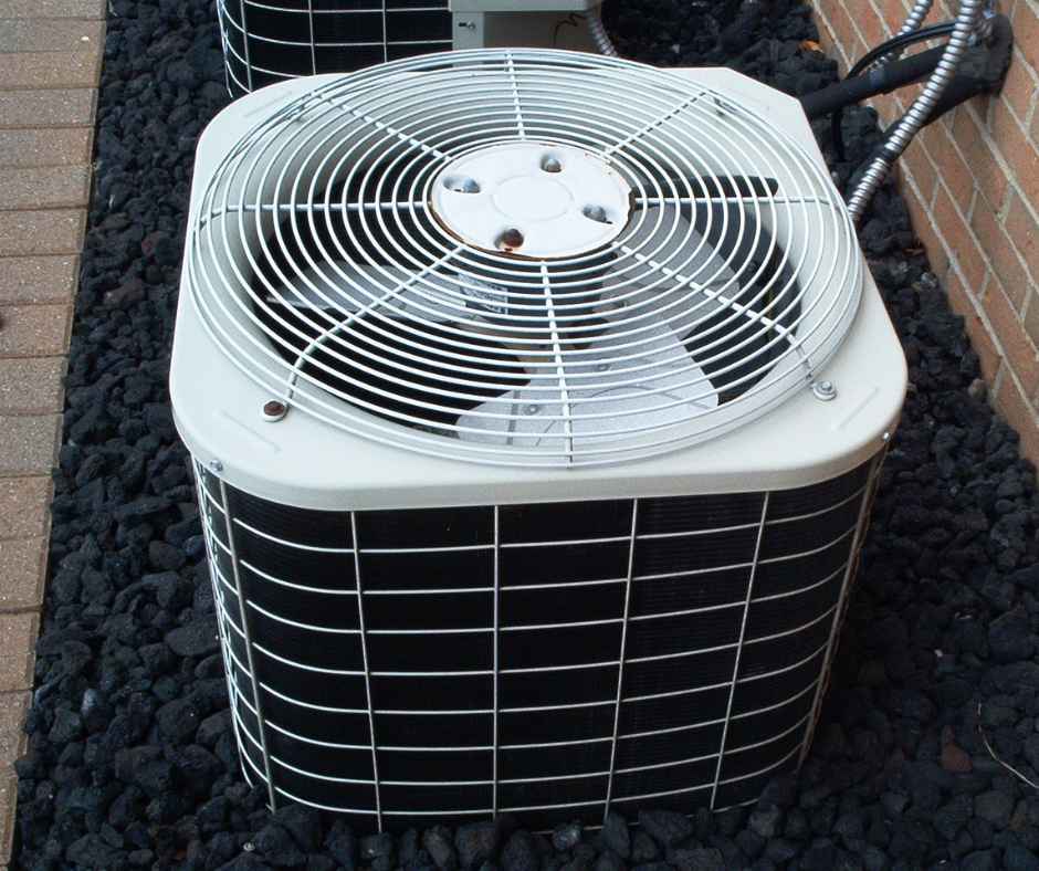 Air conditioner outside a home surrounded by rocks
